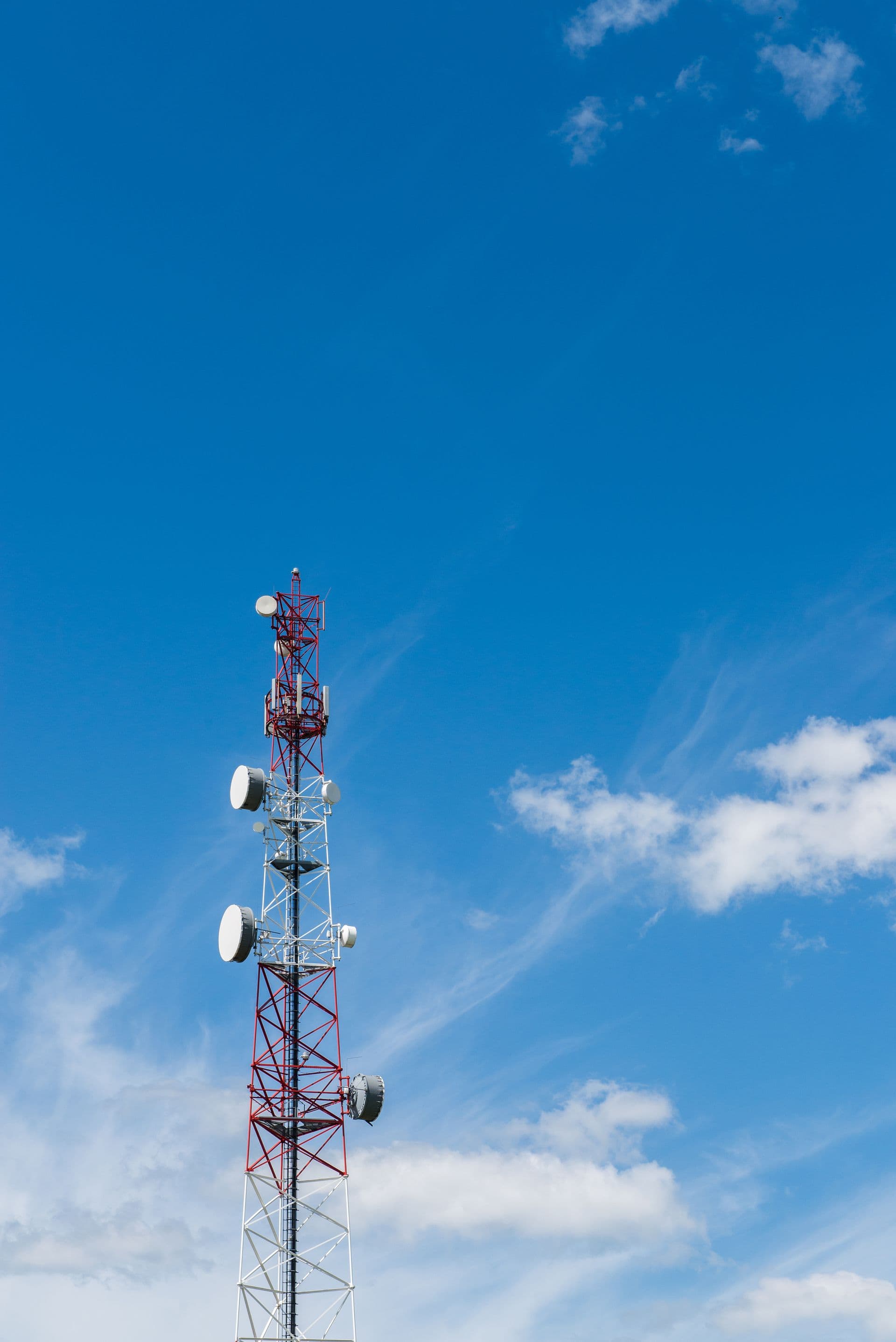 Telecommunications tower with microwave antennas against a clear blue sky